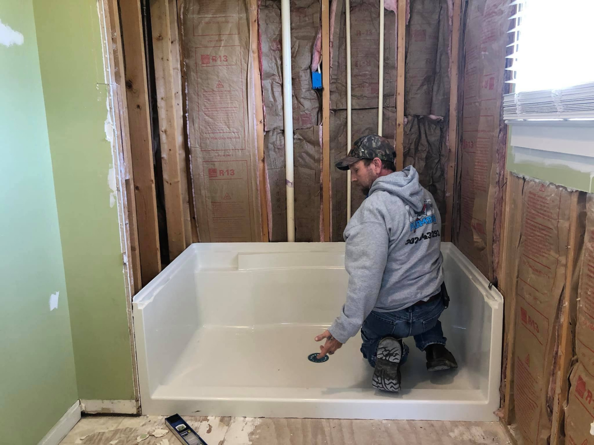 C & B Plumbing technician setting a new shower pan during a bathroom remodel